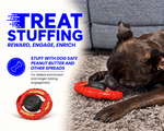 A brindle dog lies on a gray carpet chewing a red treat-stuffing toy, with large blue text on the left reading 'TREAT STUFFING' and product callouts about dog-safe peanut butter and other spreads.